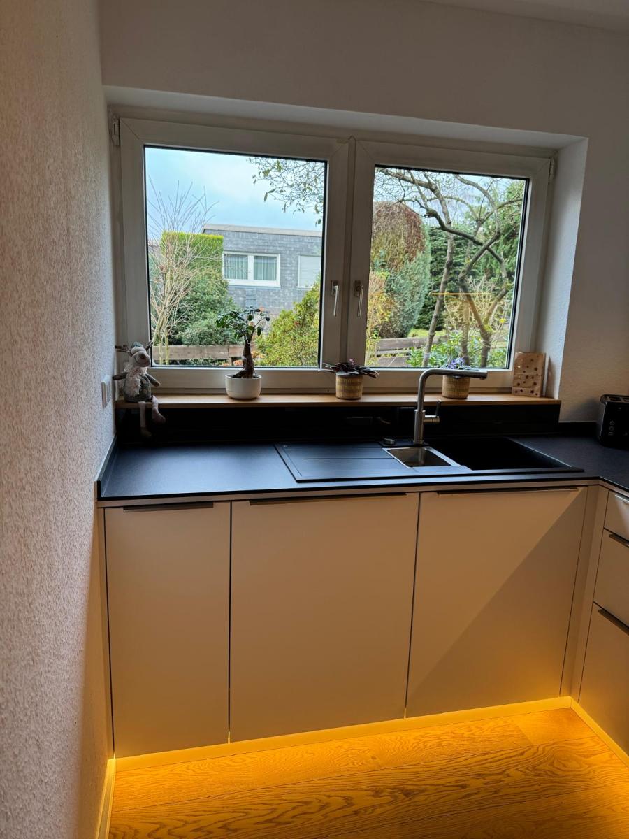 Eingelassene Spüle mit Spritzschutz zur Fensterbank.